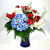 Red, white, and blue flower arrangement in a blue vase