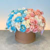 Round box arrangement of blue, pink, and white roses
