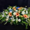 Low floral spray with peach gerberas, white blooms, and blue hydrangeas
