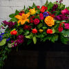 Colorful mixed bouquet with roses and lilies on a dark cloth