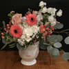 Bouquet of pink gerberas, white hydrangeas, and roses in a face vase