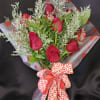 Bouquet of red roses with white filler and a heart-patterned ribbon