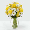 Yellow roses and white daisies in a clear glass vase