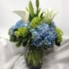 A sophisticated display of fresh elegant flowers handcrafted in a glass vase.