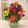 Colorful bouquet of roses, lilies, and carnations in a glass vase