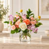 Mixed bouquet of roses and pink flowers in a clear glass vase