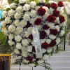 Heart-shaped standing spray of red roses and white carnations on an easel
