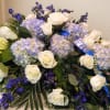 White roses and lavender hydrangeas with blue ribbon on a low floral spray