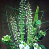 Tall floral arrangement with white orchids and green accents