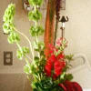 Tall arrangement with red and purple flowers in a black vase