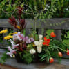 Mixed floral arrangement with orchids, roses, tulips, and yellow daisies