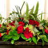 Red roses and carnations arranged on a low rectangular base