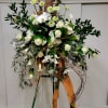 Tall floral arrangement with white roses and calla lilies on branches