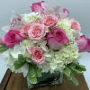 A lush vase design of hydrangea, roses, spray roses and Cymbidium orchid.