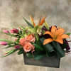 Mixed bouquet with orange lilies, pink roses, and tulips in a black box