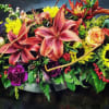 Mixed bouquet with lilies, roses, sunflowers, and purple blooms