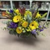 Yellow and purple mixed bouquet in a square glass vase