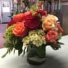Mixed roses and hydrangeas arranged in a glass vase