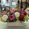 Mixed pink and white flowers arranged in a wooden box