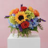 Colorful bouquet with sunflowers, roses, and hydrangeas in a glass vase