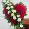 Heart-shaped floral arrangement with red flowers and white roses