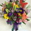 Colorful mixed bouquet in a clear glass vase with a red butterfly pick