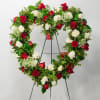 Heart-shaped wreath of red and white roses on a stand