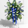 Standing floral spray with white roses, blue flowers, and a blue ribbon