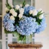 Blue hydrangeas and white roses in a glass vase