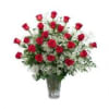 Red roses in a clear glass vase with white filler flowers