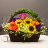Basket arrangement with sunflowers, roses, orchids, and tulips
