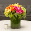 Colorful bouquet of roses and hydrangeas in a green glass vase