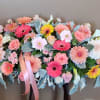 Large pastel floral arrangement with pink and white blooms and ribbon