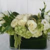 White roses and tulips arranged in a dark green vase