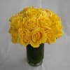 Yellow roses arranged in a green glass vase