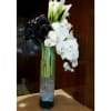 Tall white orchid and calla lily arrangement in a glass vase