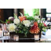 Low floral centerpiece with white and peach blooms in a dark rectangular container