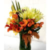 Orange and yellow calla lilies arranged in a dark glass vase