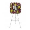Floral funeral wreath on an easel with a portrait in the center