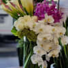 White calla lilies, orchids, and roses in a glass vase