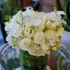 White floral bouquet in a green glass vase