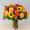 Mixed bouquet of roses and sunflowers in a clear glass vase
