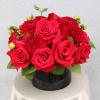 Red roses and red mums arranged in a black round box