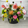 Colorful mixed flower arrangement in a black container