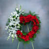 Two floral funeral wreaths, one red and one white, on easels