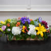 Colorful mixed flower arrangement in a low wooden box