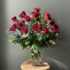 Tall bouquet of red roses in a clear glass vase