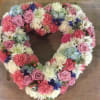 Heart-shaped floral wreath with pink, white, and blue flowers