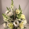 White and pale yellow flowers in a wicker basket arrangement