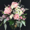 Pink roses and white flowers arranged in a glass vase